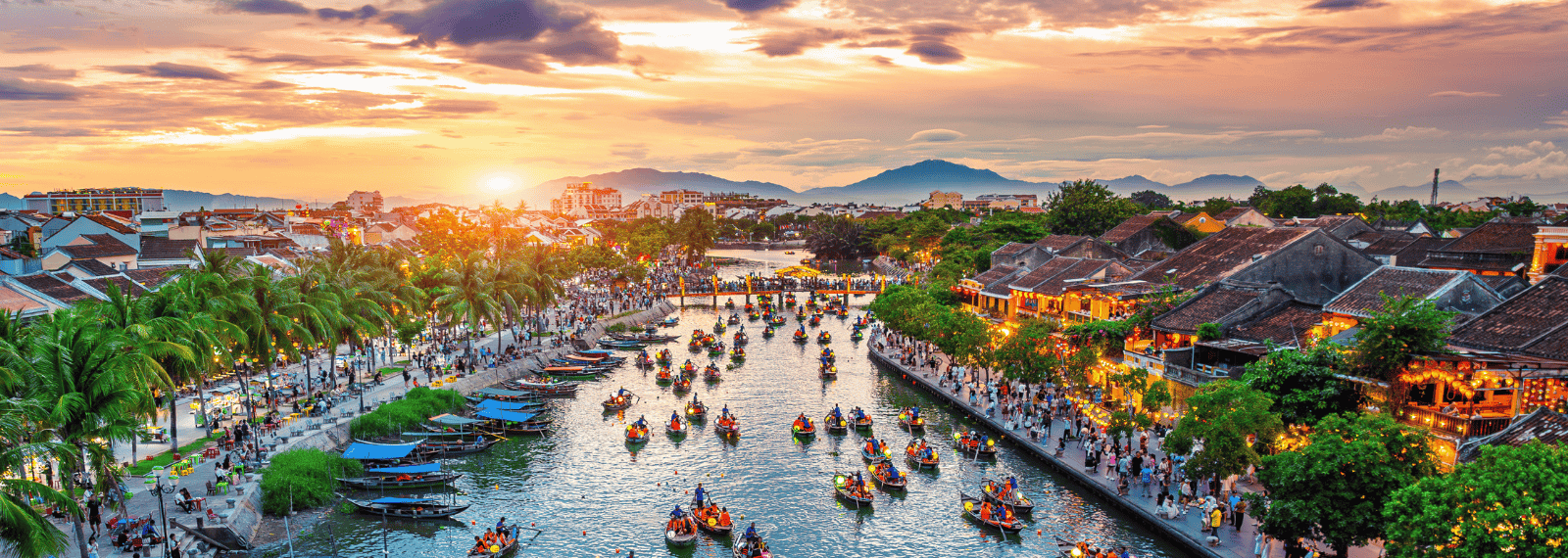 Lanternes colorées et bateaux traditionnels sur la rivière Hoai à Hoi An illuminée le soir