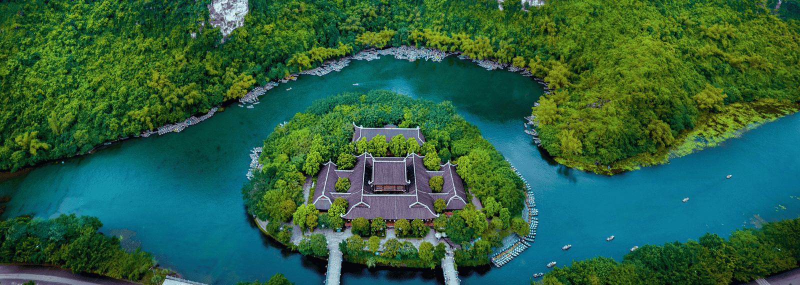 Temple traditionnel niché sur une île verdoyante au milieu des eaux paisibles de Ninh Binh, vu d'en haut