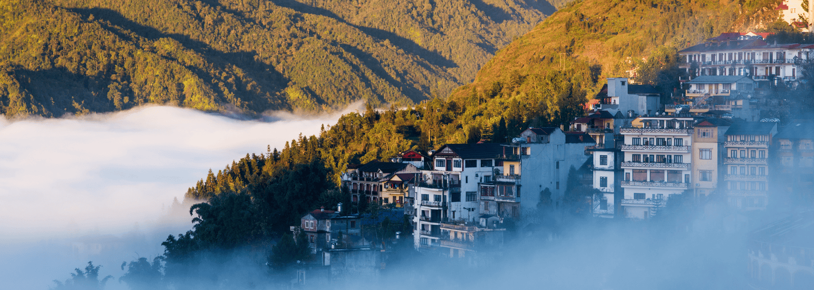 Vue panoramique de la ville de Sa Pa nichée dans les montagnes et entourée de brume au lever du soleil
