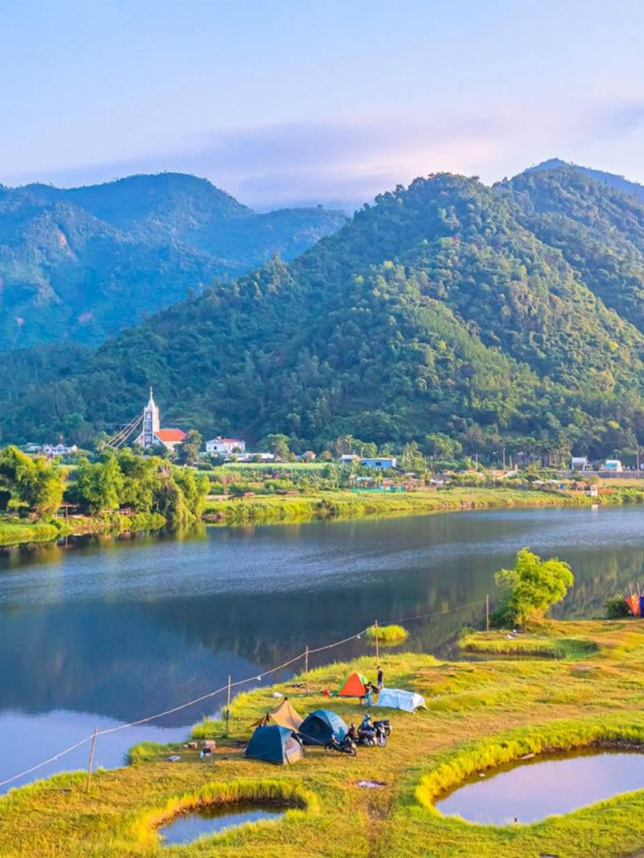 Zone de camping paisible au bord d'un lac entouré de montagnes verdoyantes à la périphérie de Da Nang